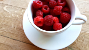 Antioxidant-filled raspberries in a white cup 