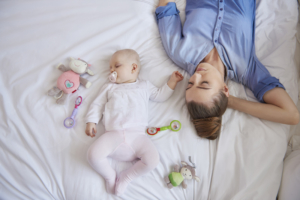Mother and baby rest on bed to strengthen immune system