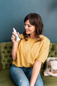 Woman holds up ACZ Nano Zeolite from Ultimate Body Detox by Results RNA