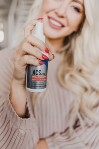 Woman holds ACS 200 silver immune support supplement