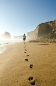 woman walking on beach to benefit health