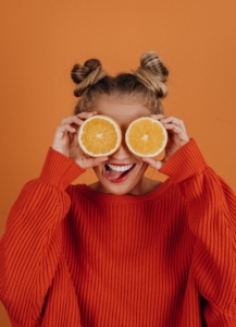 woman holds up immune supporting fruit to her face