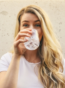 woman drinks water for detoxification and self-care