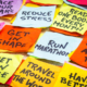 realistic and unrealistic new year goals or resolutions - colorful sticky notes on canvas