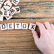 detox. Wooden letters on the office desk, informative and communication background.
